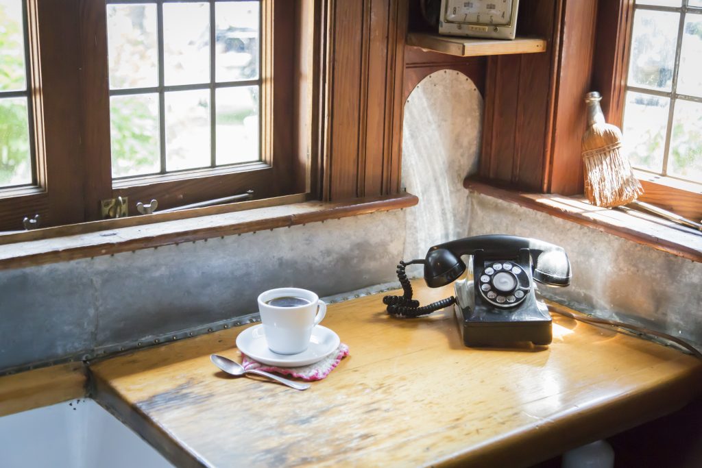 classic antique table with phone and cup and saucer