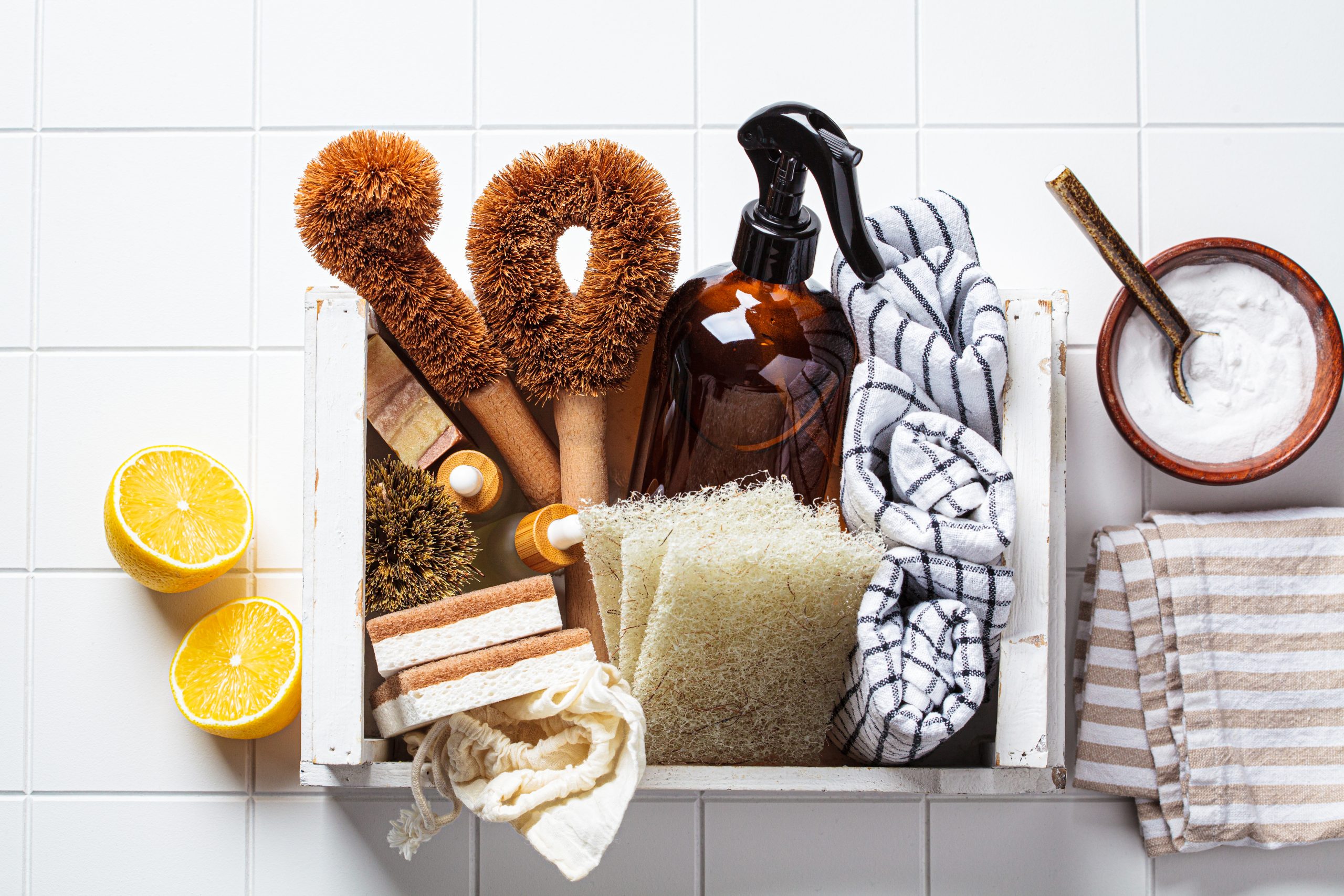 Natural cleaning supplies with brushes, cloths, lemon and baking soda