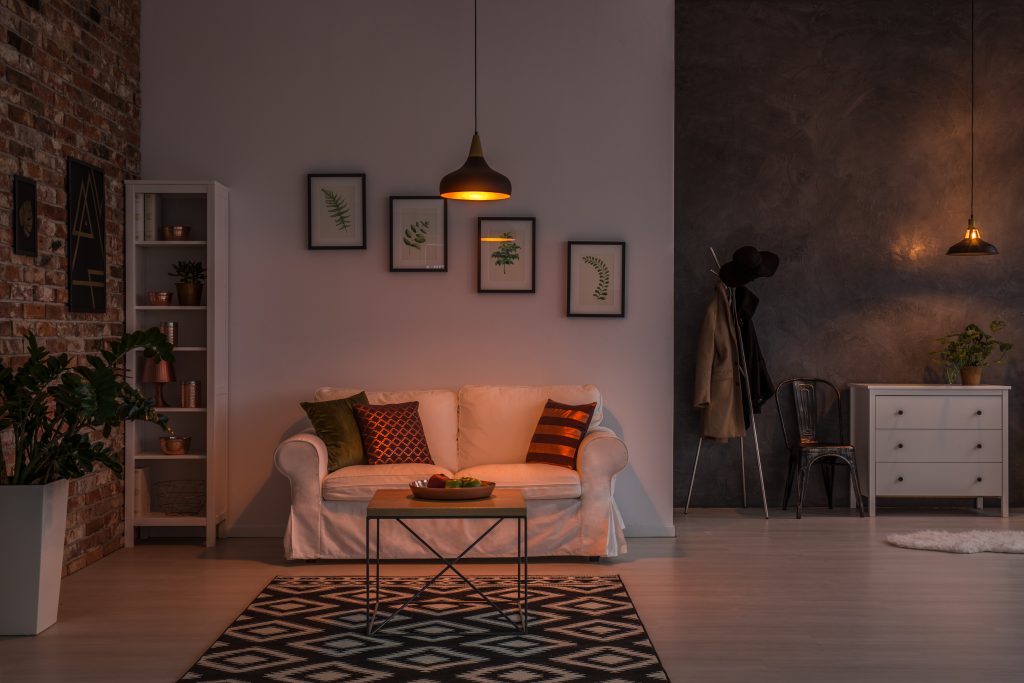 Cozy living room with a sofa, framed art and warm evening lighting