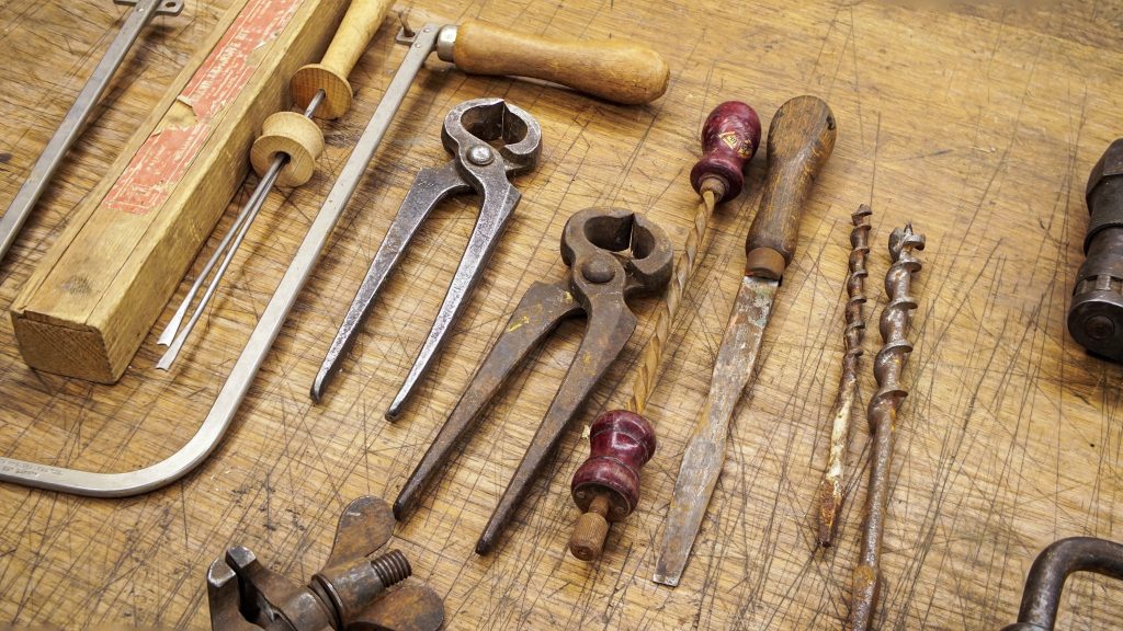 Traditional woodworking hand tools laid out on a workbench