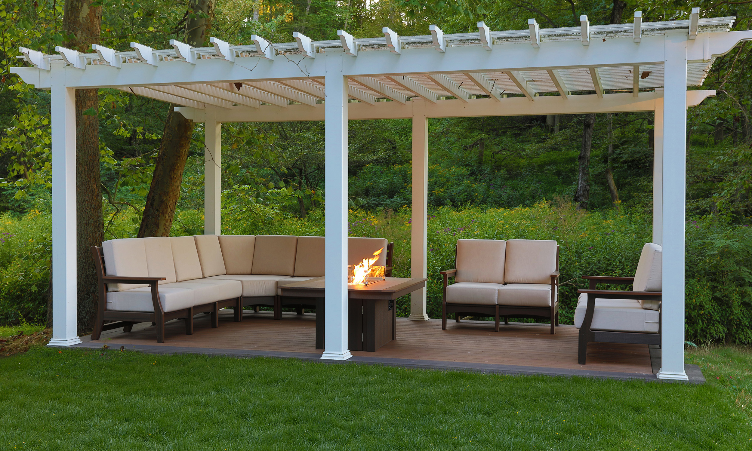 White pergola over a deep-seating outdoor sofa set and fire table