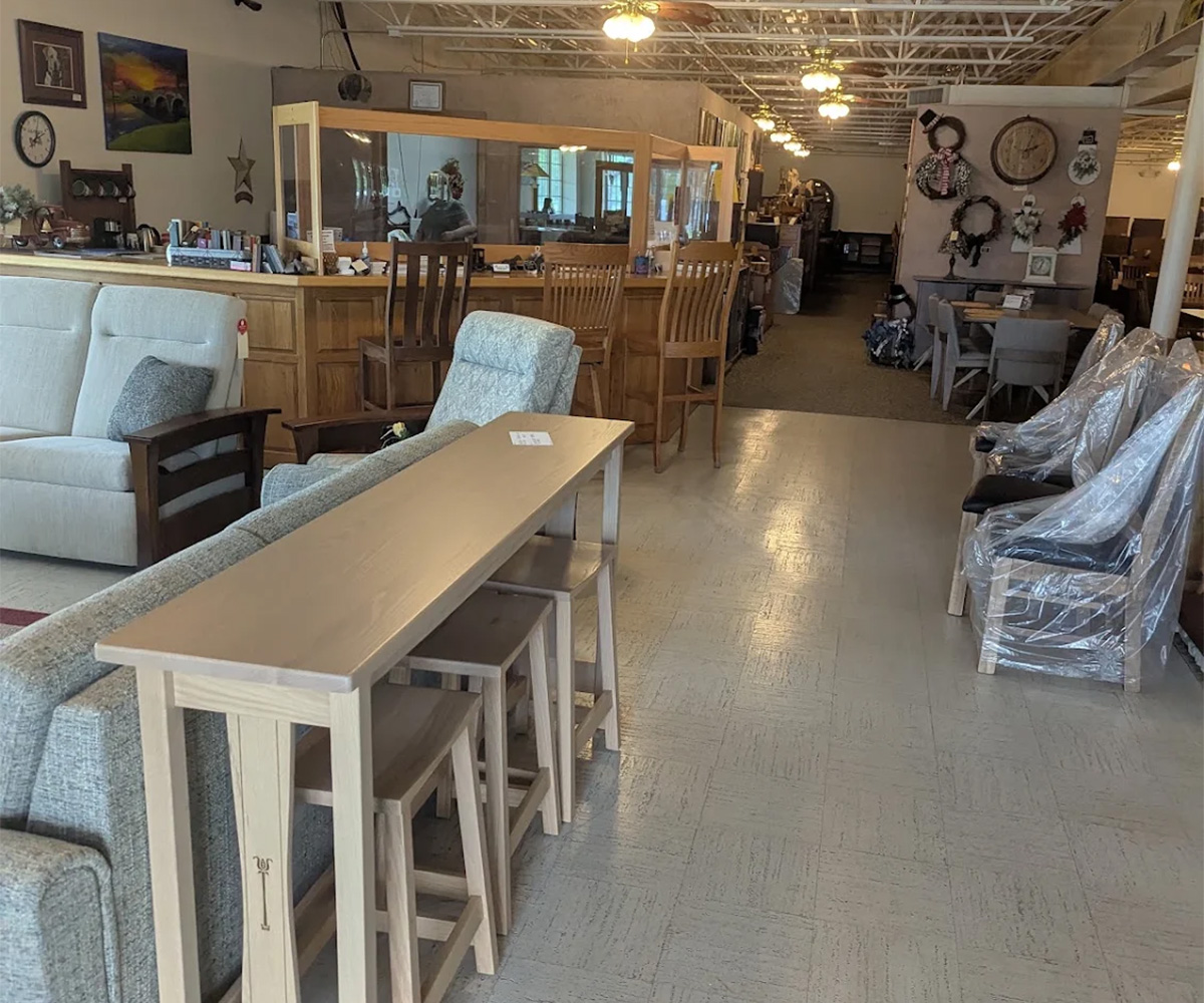 Furniture showroom floor with counter-height table, stools and sofas