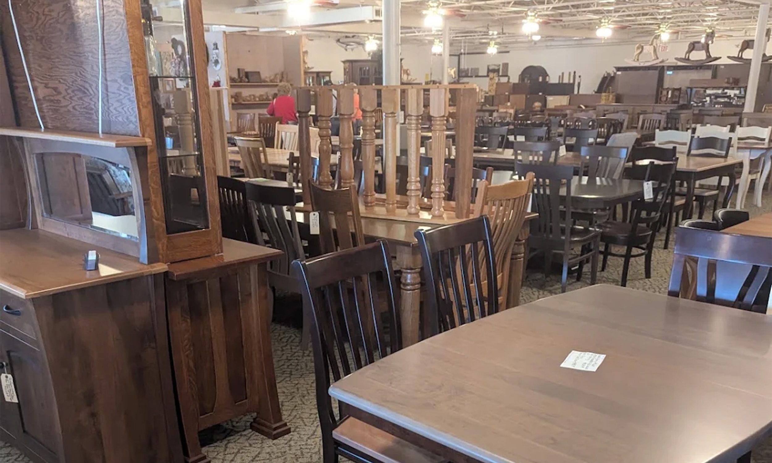 Showroom aisle of solid wood dining tables, chairs and hutches